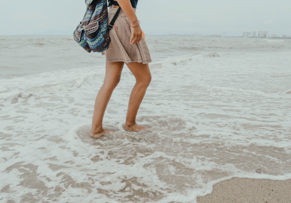 Woman walking on the beach to stop living in the past.