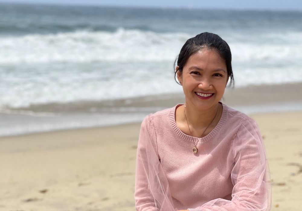 Woman on a beach learning how to glow up.